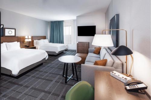 a hotel room with a bed and a couch at Staybridge Suites Waco South - Woodway by IHG in Woodway