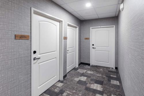 a hallway with two white doors and a tile floor at Staybridge Suites Waco South - Woodway by IHG in Woodway