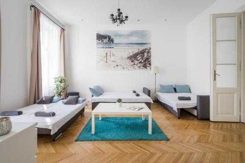 a living room with two beds and a table at Real Apartments Vadász in Budapest