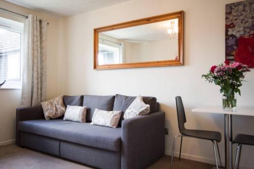 a living room with a blue couch and a mirror at 1 bedroom, self check-in, central and quiet apartment up to 3 in Newbury in Newbury