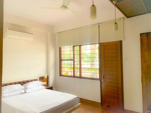 a bedroom with a bed and a window and a door at Bhola Bhawan Bed and Breakfast in Jaipur