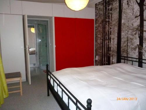a bedroom with a bed with a red wall at Ferienwohnung Tietgen in Rendsburg