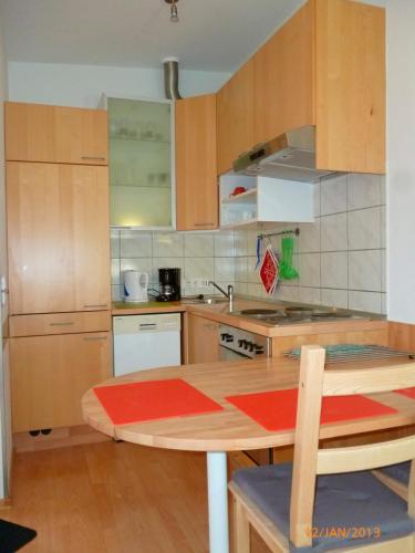 倫茨堡的住宿－Ferienwohnung Tietgen，厨房配有木制橱柜和木桌。