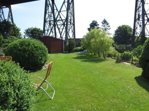 une chaise en métal assise dans l'herbe dans un parc dans l'établissement Ferienwohnung Tietgen, à Rendsburg