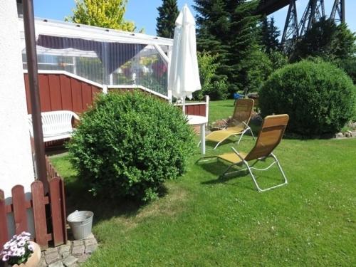 einen Hof mit zwei Stühlen und einem Regenschirm in der Unterkunft Ferienwohnung Tietgen in Rendsburg