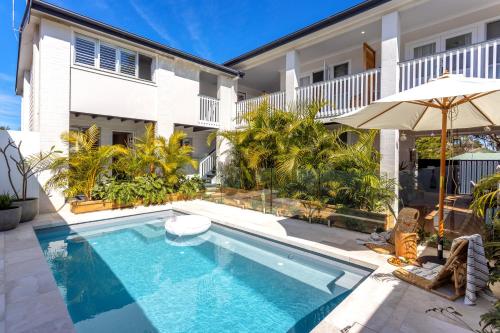 a swimming pool in front of a house at Finns at Old Bar in Old Bar