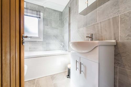 a bathroom with a sink and a bath tub at Hideaway by Liv Retreats in Lincoln