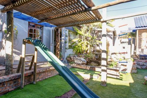 a playground with a slide in a yard at Strand Double En-Suite Studio in Cape Town