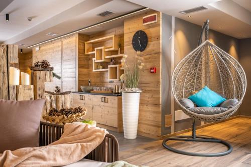 a hanging chair in a room with a kitchen at Cesa Edelweiss Living & Spa in Campitello di Fassa