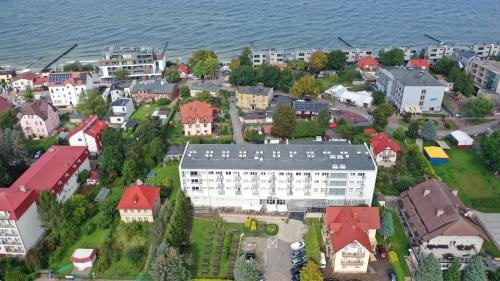 una vista aerea di una città con un edificio bianco di ALKA Sun Resort a Ustronie Morskie