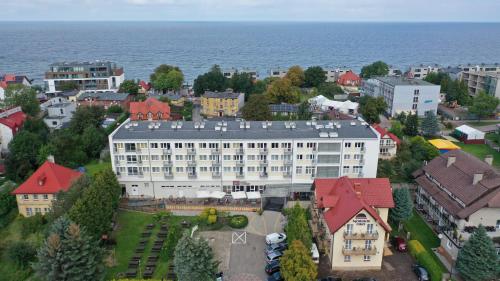 an aerial view of a large white building with red roofs at ALKA Sun Resort in Ustronie Morskie