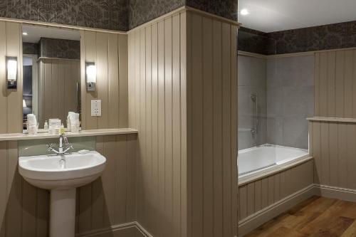 a bathroom with a sink and a bath tub at Langdale Hotel & Spa in Ambleside