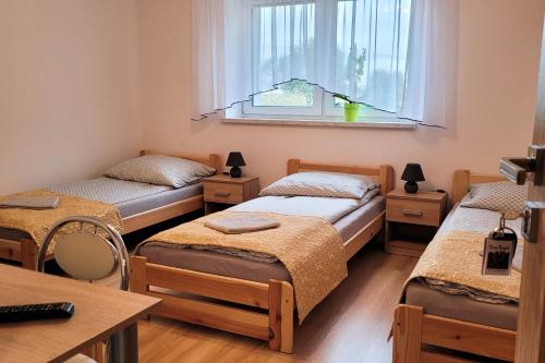 3 camas en una habitación con ventana en Dwa Karpie Jedlicze, en Jedlicze
