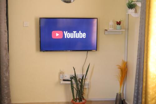 a flat screen tv hanging on a wall at Tom Mboya Estate - Fast WI-FI, Netflix and Parking 1Br Apartment in Kisumu Town in Kisumu