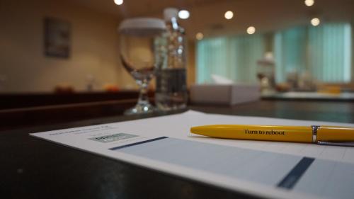 a yellow pen sitting on top of a paper on a counter at Golden Tulip Sharjah in Sharjah