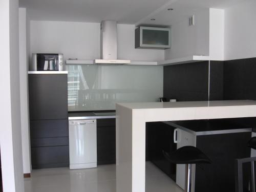una cocina con armarios en blanco y negro y una encimera en Luksusowy apartament w Ustroniu, en Ustroń