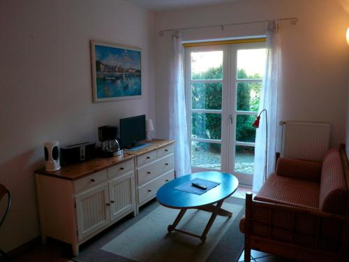 sala de estar con escritorio, ordenador y mesa en Landhaus-Marwede App 2, en Haffkrug
