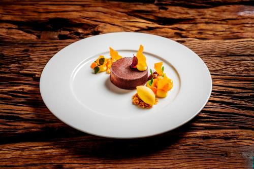 a white plate with a chocolate dessert on a table at Relais & Châteaux Landhaus Stricker in Tinnum