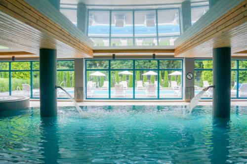 a swimming pool with two people in the water at Villa Park Med. & SPA in Ciechocinek