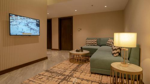 فندق ايرس بوتيك جازان  في جازان: غرفة معيشة مع أريكة وتلفزيون بشاشة مسطحة