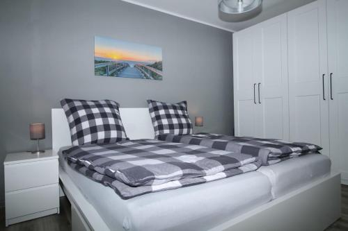 ein Bett mit zwei Kissen auf einem Zimmer in der Unterkunft Ferienhaus Sonnenblick mit Sauna Harkebrügger See in Barßel