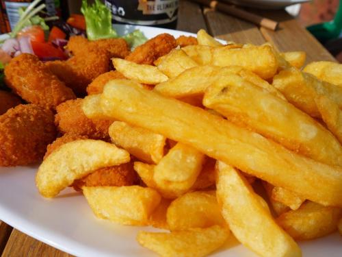 a plate of food with french fries on a table at The Trouville in Torquay