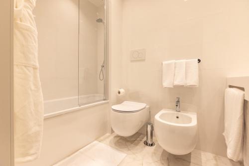 a white bathroom with a toilet and a shower at Hotel Morfeo in Milan