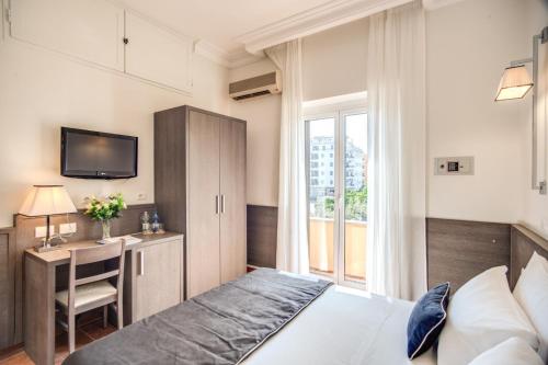 una camera con letto, scrivania e TV di Hotel Mirti a Roma