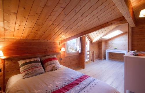 une chambre avec un lit dans une cabane en bois dans l'établissement Odalys Chalet Le Panorama, à Les Deux Alpes