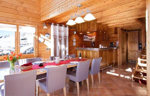 une salle à manger avec une table et des chaises dans une cabine dans l'établissement Odalys Chalet Le Panorama, à Les Deux Alpes