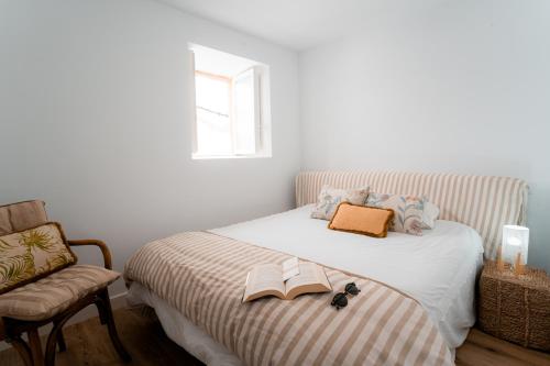 una camera con un letto con un libro e una sedia di Casa dos Infantes a Muros
