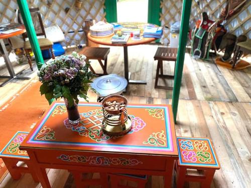 a table with a vase of flowers on a table at Mongolian Yurt Camp in Český Šternberk
