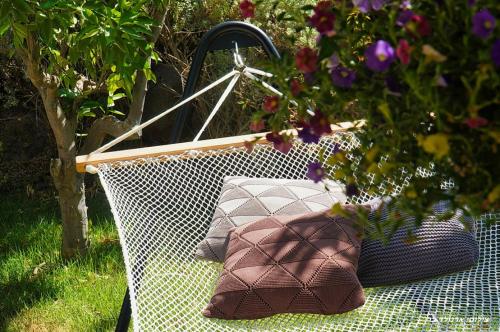 a bench with two pillows on it in a garden at Nola in Had Nes