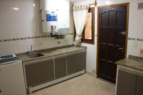 a small kitchen with a sink and a door at Acacias Blancas in Costa del Este