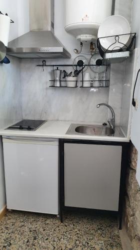 una cocina con armarios blancos y fregadero en Fabrica de Harina, en Ventas con Peña Aguilera