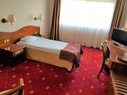 Uma cama ou camas num quarto em Hotel Sympozjum & SPA