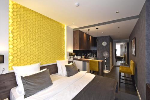 a bedroom with a large bed and a yellow wall at Avenue ApartHotel in Yerevan