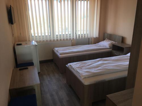 a small room with two beds and a window at Cazare Hofmann in Arad