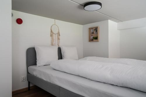a white bedroom with two beds and a ceiling at RentPlanet - Apartamenty Zarembowicza II in Wrocław