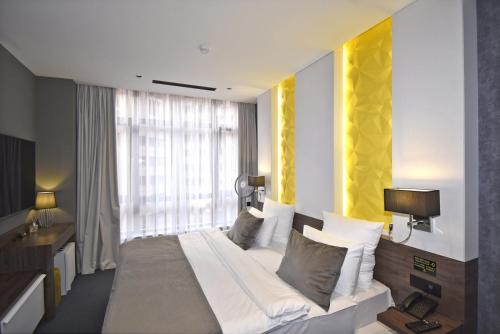 a bedroom with a large bed and a window at Avenue ApartHotel in Yerevan
