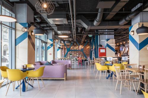 ブダペストにあるB&B Hotel Budapest Cityの紫と黄色の椅子とテーブルが備わるレストラン
