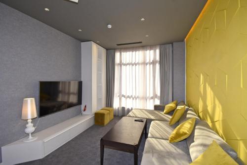 a hotel room with a bed and a tv at Avenue ApartHotel in Yerevan
