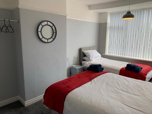 1 Schlafzimmer mit 2 Betten und einem Wandspiegel in der Unterkunft Modern fully refurbished 3 bedroom home in Blackpool