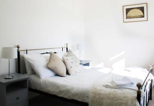 Una cama con sábanas blancas y almohadas en un dormitorio en Oxford - Private House with Garden & Parking 05, en Oxford