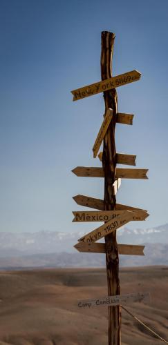 a directional sign in the middle of the desert at Camp Cameleon in Marrakech