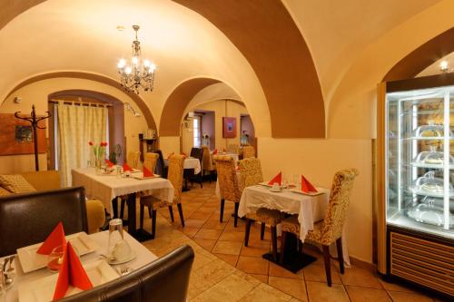 une salle à manger avec des tables et des chaises dans un restaurant dans l'établissement Enjoy Inn, à Plzeň