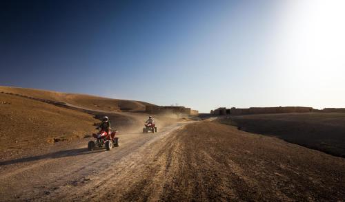 two people riding motorcycles on a dirt road at Camp Cameleon in Marrakech
