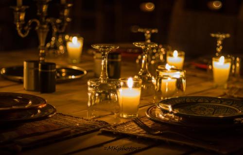 a table with candles and plates and glasses on it at Camp Cameleon in Marrakech