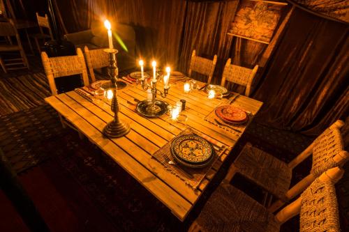 a wooden table with candles on top of it at Camp Cameleon in Marrakech