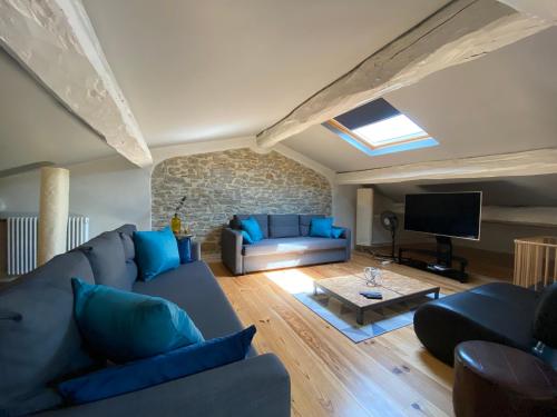 sala de estar con sofá azul y TV en Le Logis GOUT en Carcasona